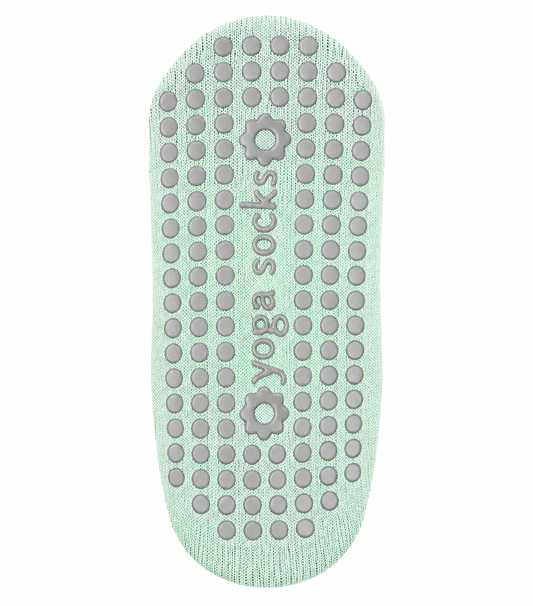 Yoga socks sole with textured grip pattern on a light green background