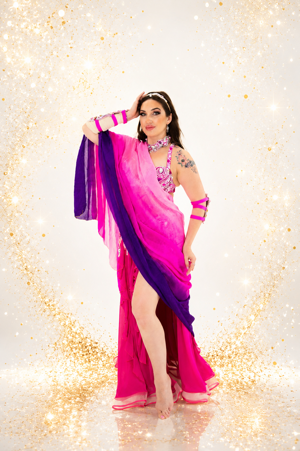 Woman in a pink and purple saree with a glittery background